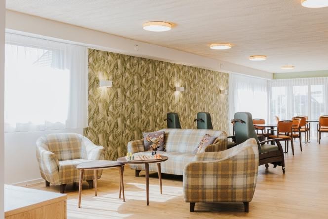 Tagespflege Hotzenwald Gemeinschaftsraum der Tagespflege. Im Vordergrund Sitzgruppe mit Sesseln und im Hintergrund sind Ruhesessel und Tischgruppen zu sehen.