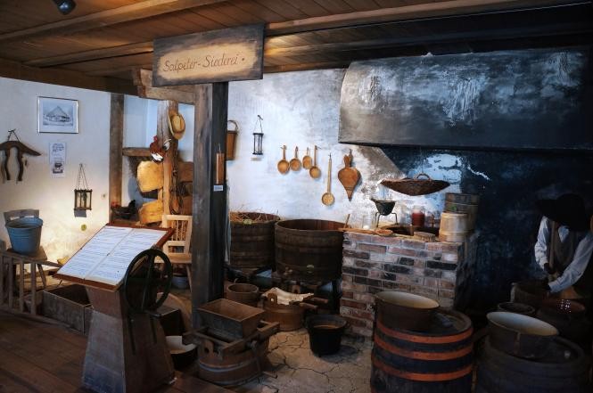 Blick auf die Salpetersiederei mit offener Feuerstelle und den Kübeln aus Holz